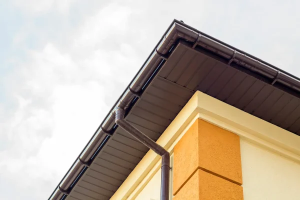 close-up-detail-of-cottage-house-corner-with-brown-metal-planks-siding-and-roof